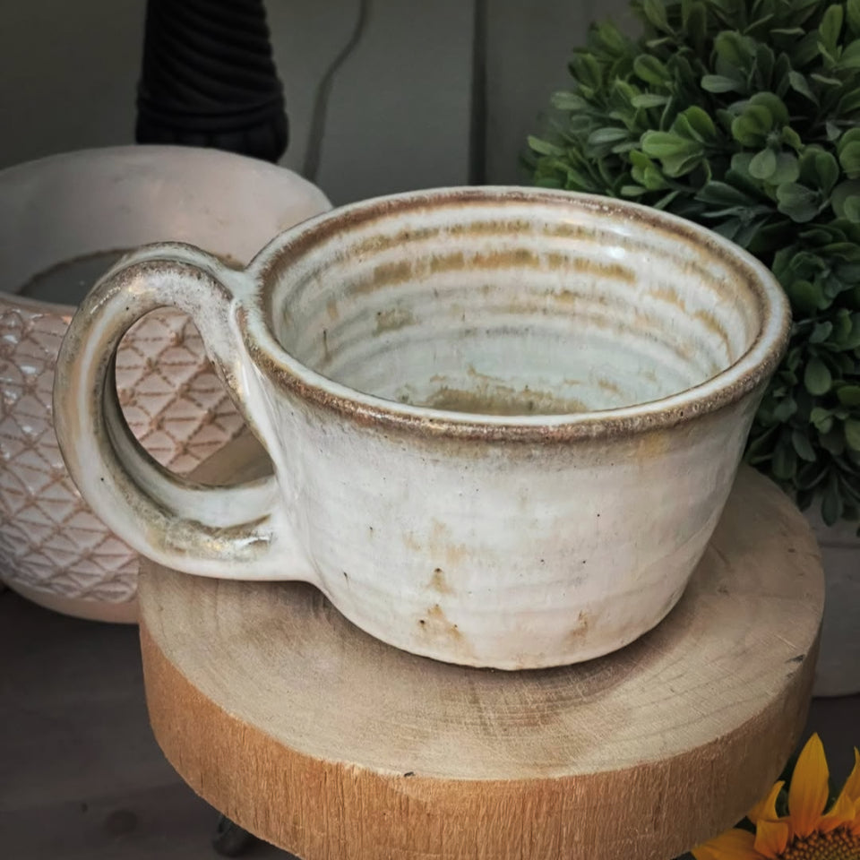 black clay ceramic mug with white glaze and swirl bottom