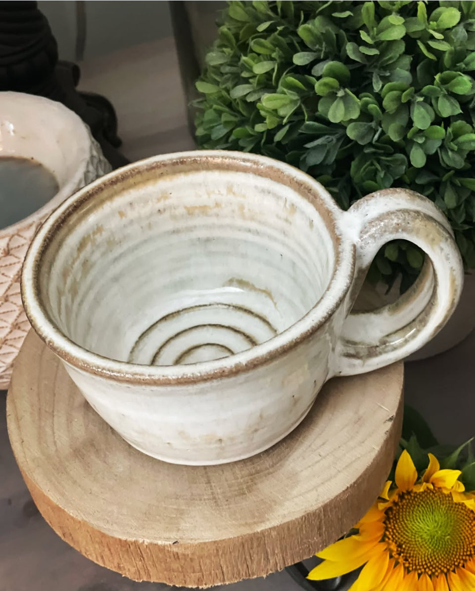 black clay ceramic mug with white glaze and swirl bottom