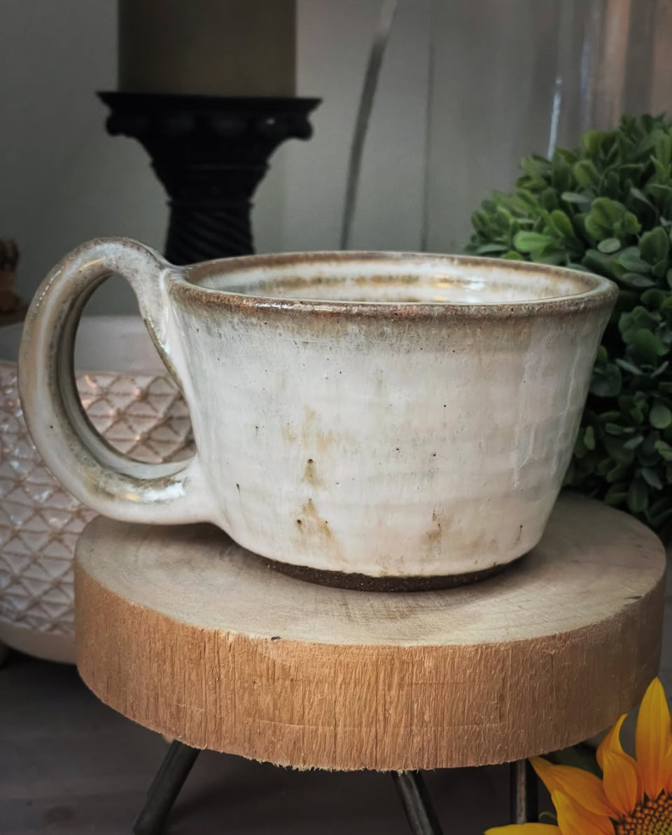 black clay ceramic mug with white glaze and swirl bottom