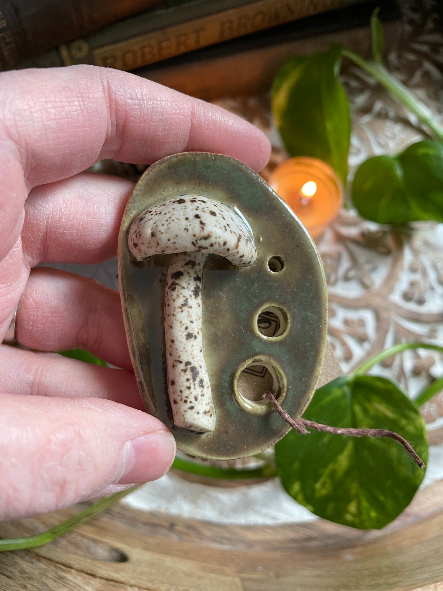Close-up of decorative mushrooms on green glazed ceramic herb stripper
